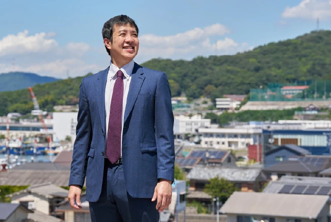 街並みを背景に微笑む代表